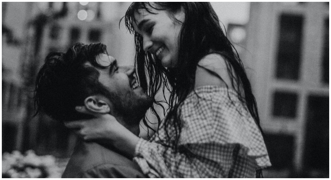 Žena a muž sa na seba smejú v daždi