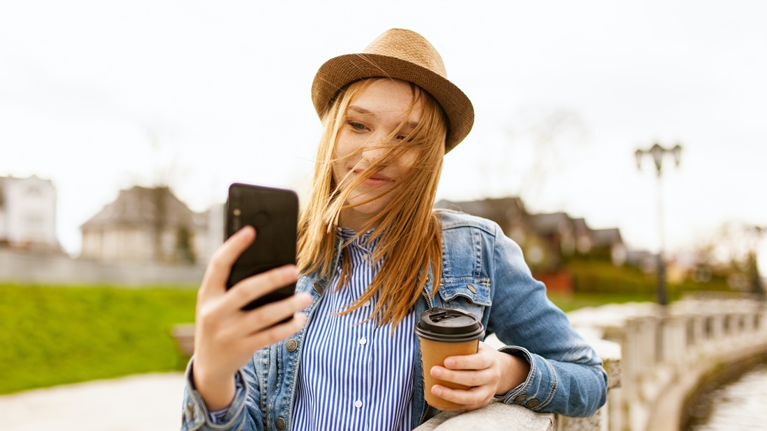 Žena s kávou v ruke si robí selfie