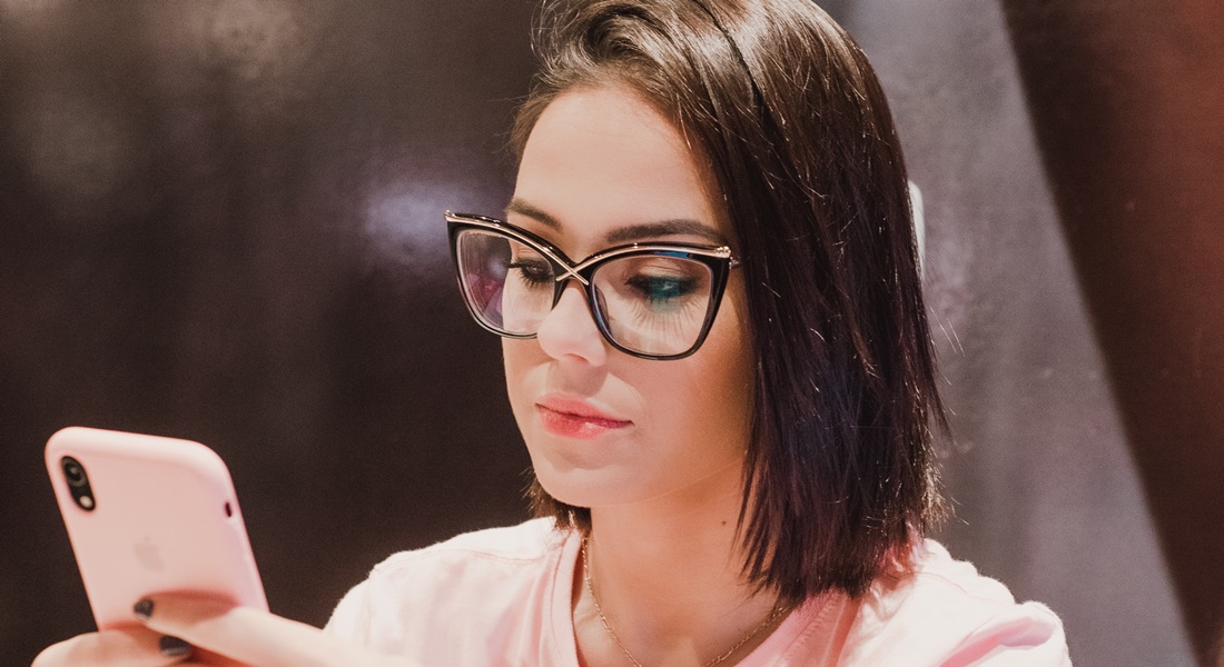 Žena v okuliaroch píše na mobile