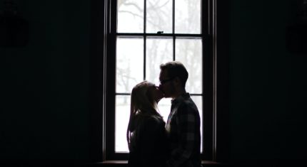 Pár sa bozkáva pri okne