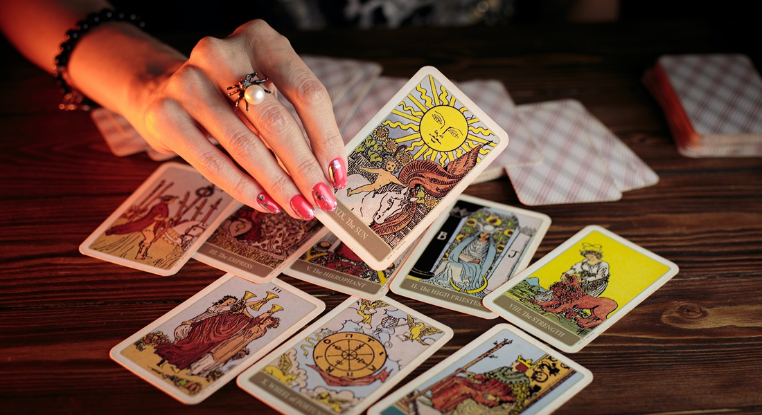 Ženská ruka drží veštecké karty