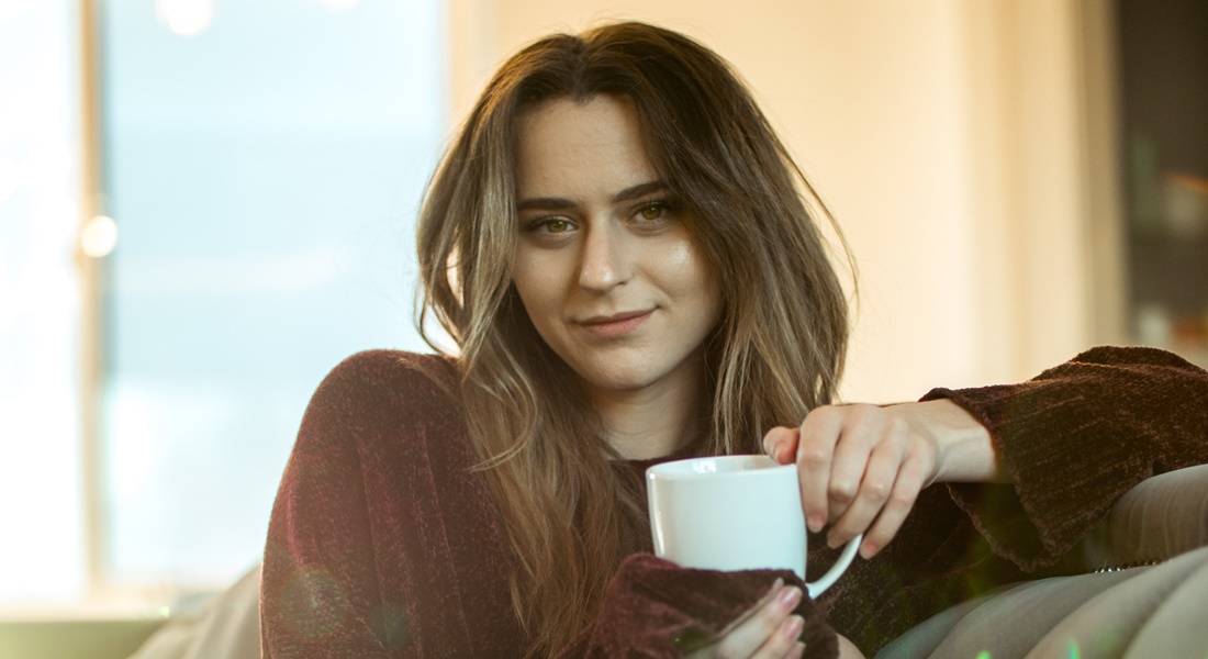 Žena drží hrnček s kávou