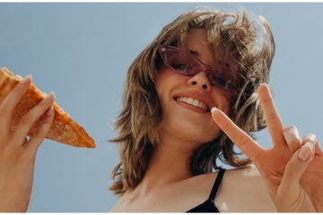 Žena v lete ukazuje "peace" a je pizzu