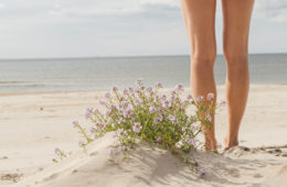 Žena ukazuje nohy na pláži