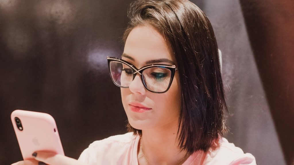 Žena s okuliarmi sa hrá s mobilom