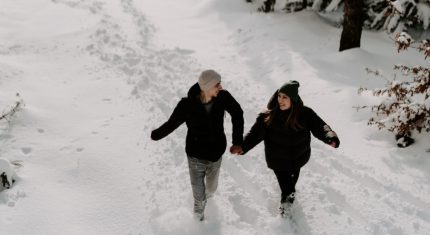 Pár beží v snehu, je medzi nimi láska