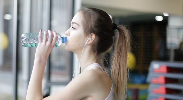 Mladá žena pije vodu