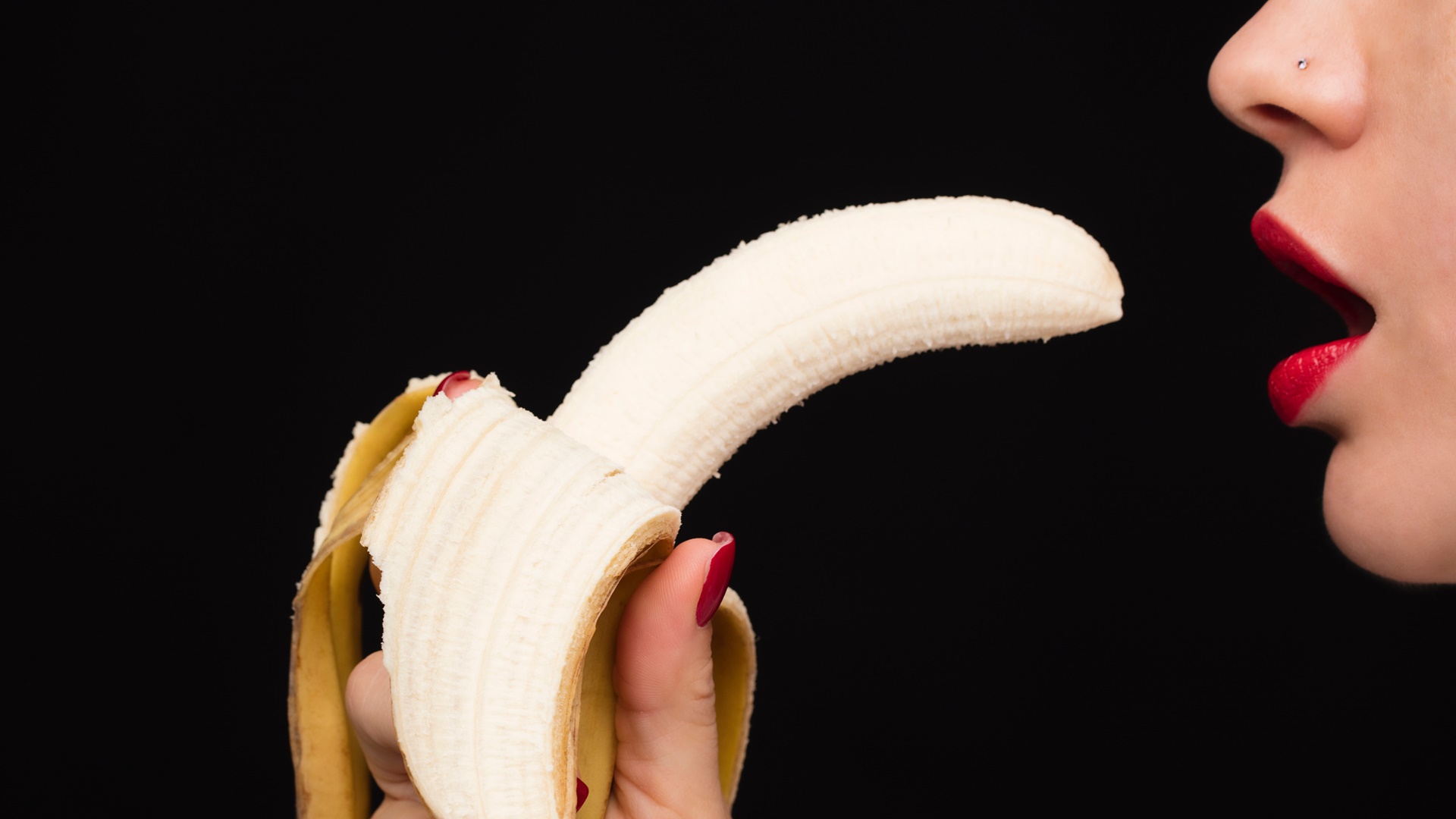 Žena si dáva banán do úst