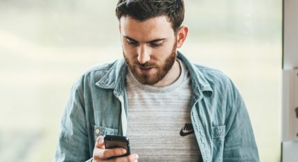 Muž po rozchode pozerá do mobilu
