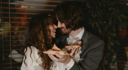 Dvojica s pizzou v ruke sa smeje