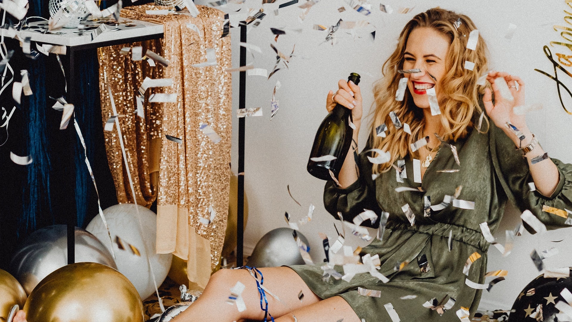 Žena oslavuje Silvester so šampanským v ruke