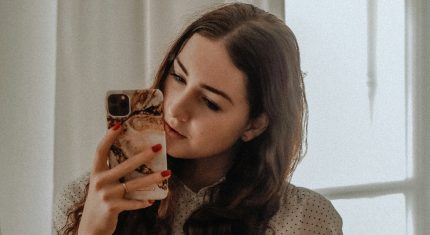 Mladá žena pozerá do mobilu